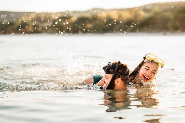 Couple s’amusant dans l’eau à Palombaggia à Porto-Vecchio, masques de snorkeling, au coucher du soleil avec lumière dorée