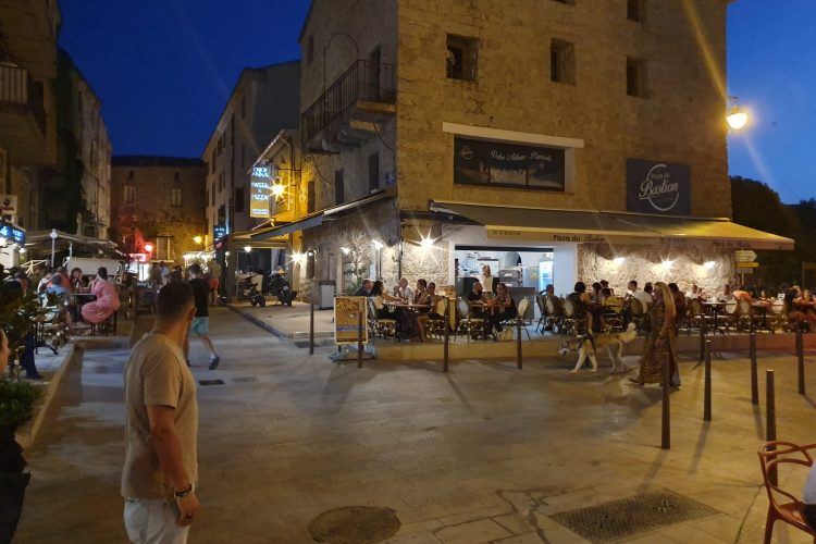 Photo prise en soirée de la terrasse extérieure du restaurant en plein service, au centre de Porto Vecchio