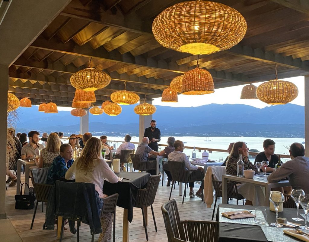 Terrasse ombragée en plein service de restauration avec vue panoramique sur le golfe de Porto Vecchio