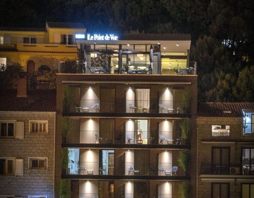 Photo de l'immeuble entier, de nuit, avec le bar à cocktails au sixième étage