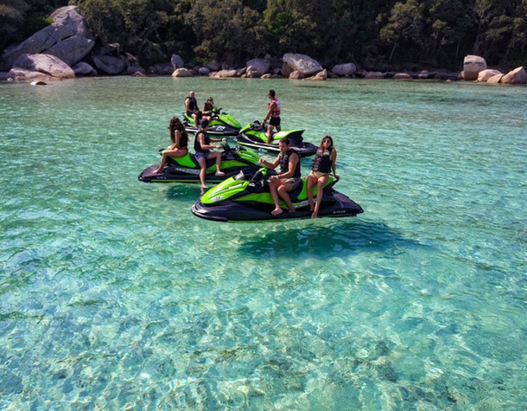 4 jet skis, regroupant 7 personnes, arrêtés dans une crique à l'eau cristalline