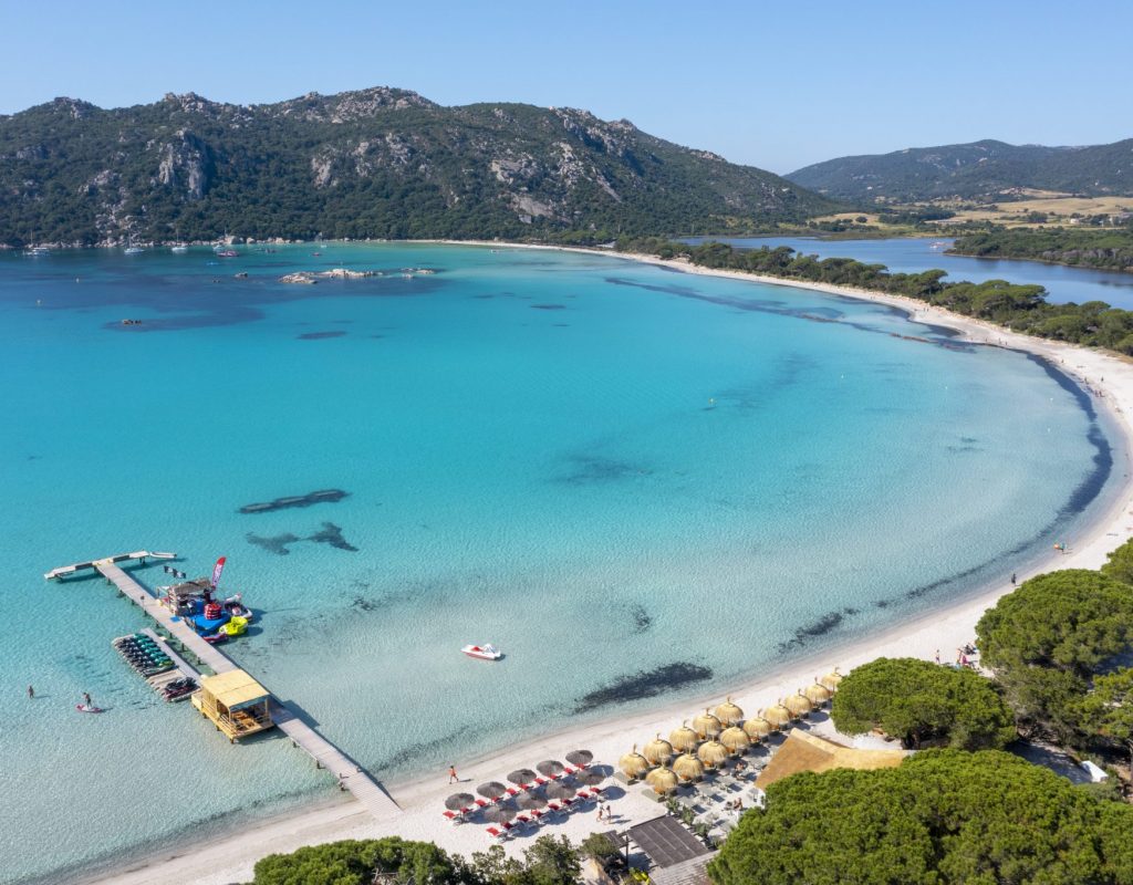 Vue aérienne de la baie de Santa Giulia ensoleillée avec la paillotte en premier plan