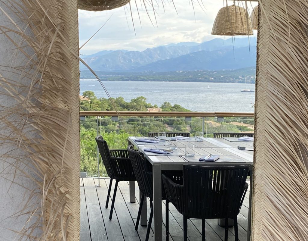 Photo d'un miroir entouré de paille qui montre le reflet de la terrasse avec vue panoramique sur le golfe de Porto Vecchio