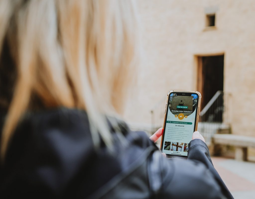 jeune femme avec l'application A Spassu sur son téléphone