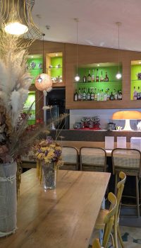 Le bar de l’Hôtel San Giovanni, baigné par une touche de vert rappelant le jardin signature de l’établissement.