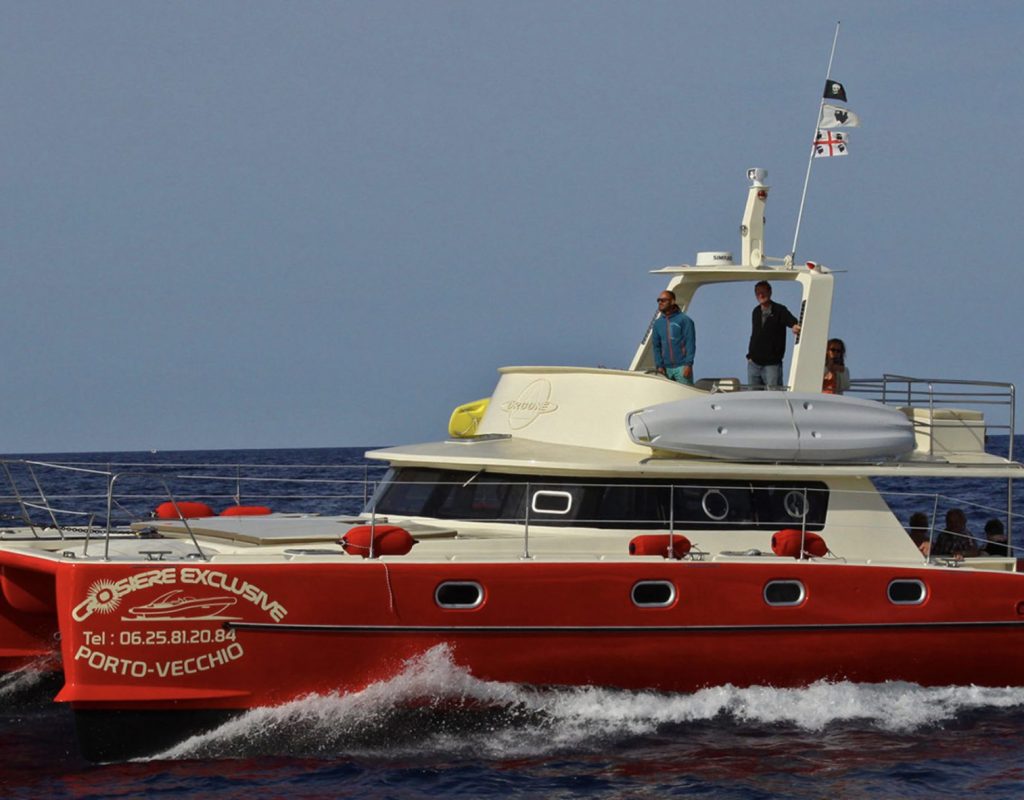 Bateau blanc et rouge navigant sur une mer bleue