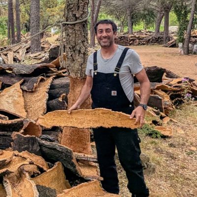 Valère Serra posant fièrement devant des tas de liège récolté à Porto-Vecchio