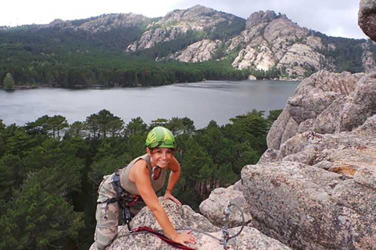 Femme que finit sont escalade, dans le panorama ont peut apercevoir le lac de l'Ospédale entouré de pins